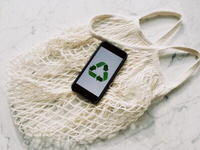 Mobile phone with green recycling sign and mesh bag