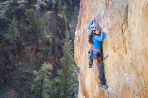 A sport climber wearing a helmet navigates a sport climb in Smith Rock