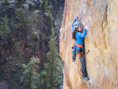 A sport climber wearing a helmet navigates a sport climb in Smith Rock