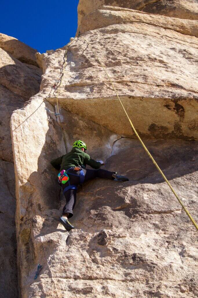 A rock climber climbs on top rope in Joshua Tree National Park. 