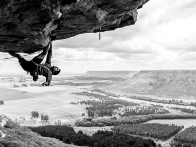 A rock climber climbs a steep roof